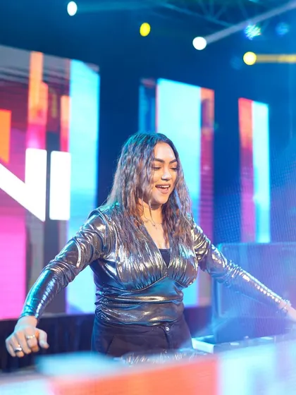 A joyful shot of me dancing behind the console, surrounded by bright, colorful stage lights.