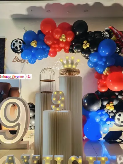 A complete car-themed setup with pedestals, a crown prop, and marquee letters for the birthday boy's name.