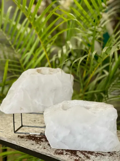 A pair of white quartz crystal planters or holders. These raw, natural formations are thought to get rid of negativity, making them a beautiful and meaningful addition to your home.