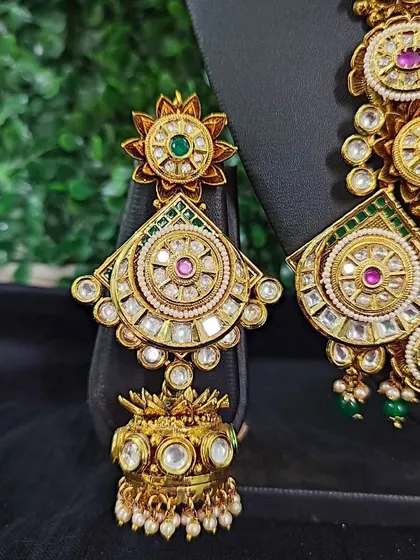 A detailed view of an earring from one of my exclusive for-sale sets. Notice the intricate circular patterns and the use of kundan with pink and green stones.