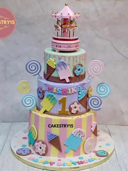 Step right up to this whimsical three-tier carousel and candyland cake. This colorful creation is decorated with fondant lollipops, ice cream cones, and donuts, and is crowned with a beautiful, classic carousel topper.