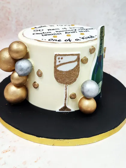 We raise a glass to a milestone birthday with this vintage champagne cake. Featuring a Moët bottle, a painted wine glass, and a personalized message, this cake is accented with gold and silver spheres for a celebratory and refined design.