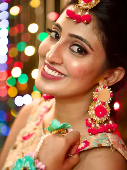 A bright, happy smile from the bride during her Mehendi. The makeup is designed to be radiant and photogenic, with a focus on glowing skin that looks healthy and fresh.