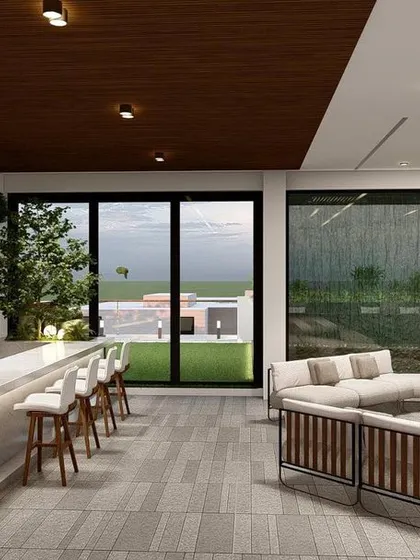 Another perspective of the covered lounge in Punjabi Bagh, showing the seamless flow from the kitchen and bar to the seating area and the view beyond.