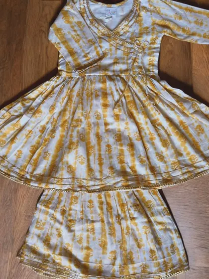 For your little girl who loves to twirl! This yellow and white Angarkha set is made from the softest cotton with just a hint of gold gota trim for that festive sparkle. It’s a traditional style made practical for modern kids who need to move.