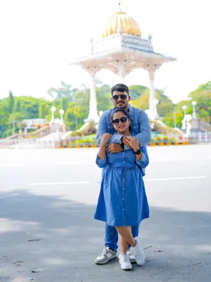 A classic couple pose in matching denim, with the beautiful architecture of Mysore in the background.