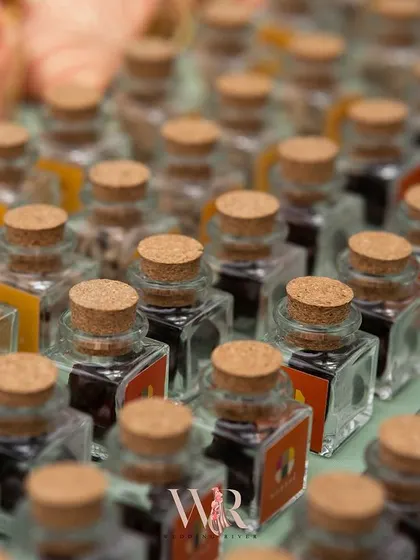 A shot of the unique wedding favors. These small, cork-stoppered bottles filled with spices or tea were a thoughtful and thematic takeaway for guests, tying into the event's natural, organic feel.
