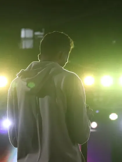 A silhouette against the green stage lights during a DJ night, capturing the cool, electric vibe.