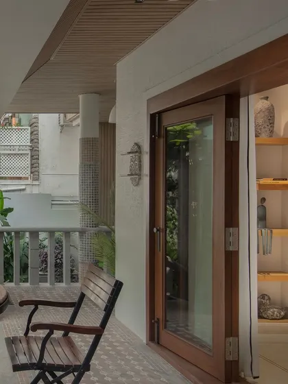 Wood-framed glass doors roll open to connect the interior to this lush green patio. The space is decorated with simple furniture and curated knick-knacks, blurring the line between indoors and out.