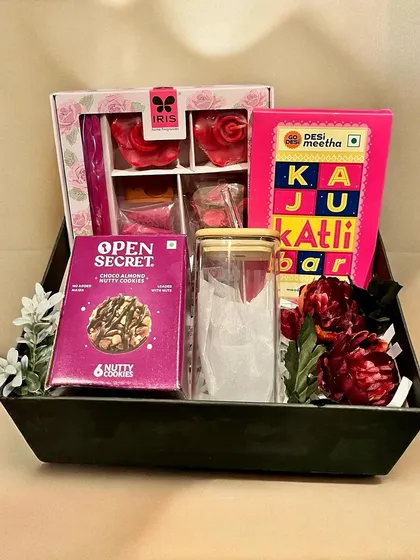 This gourmet food hamper is perfect for corporate clients and employees. It features a mix of healthy cookies, traditional Indian sweets like Kaju Katli, and fragrant potpourri in a sleek black tray.