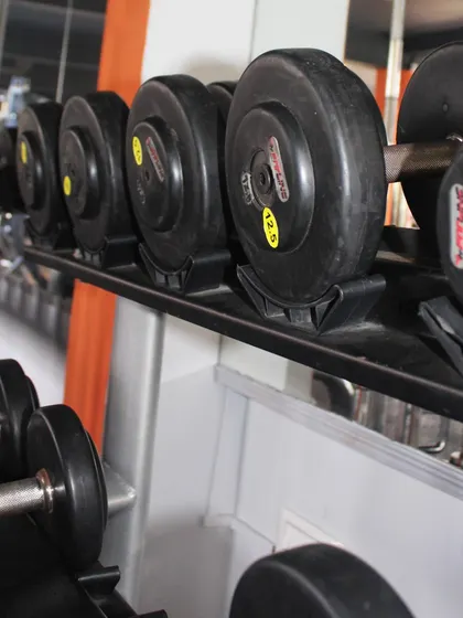A close-up of our organized dumbbell racks. We have a wide range of weights, ensuring that you can progressively increase the challenge as you get stronger.