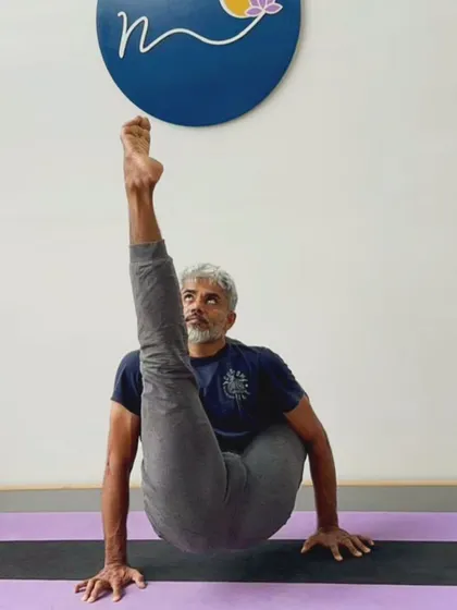 Chakorasana, an advanced arm balance that combines elements of a leg-behind-head pose and an inversion. This asana challenges balance, strength, and flexibility simultaneously.