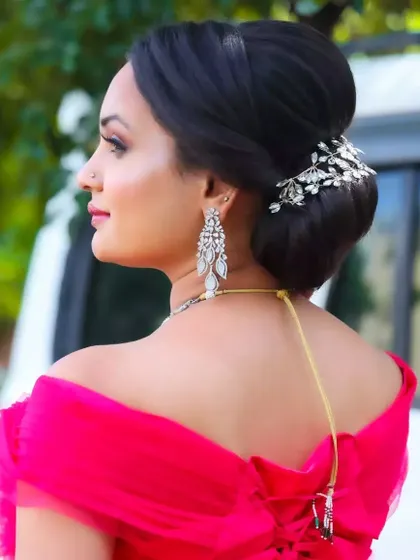 This angle showcases the elegant low bun with a crystal hair accessory. It's a perfect example of how a hairstyle can complete a modern, sophisticated look.