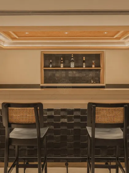 A close-up of the bar seating, with simple, elegant bar stools that feature a classic cane weave, adding another layer of natural texture.