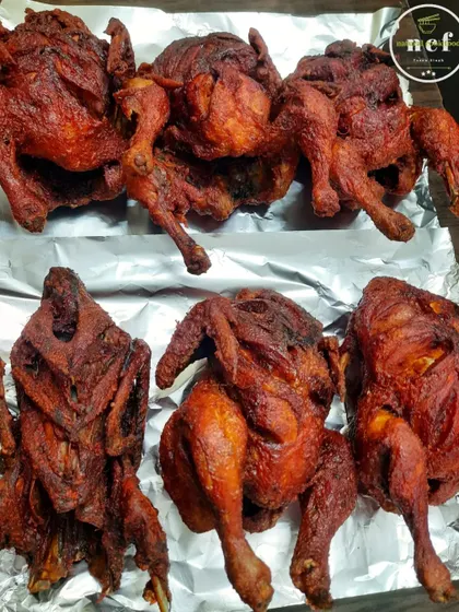 A batch of whole fried chickens, crispy on the outside and juicy on the inside.