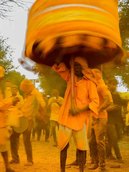 Action shots and crowd scenes from the turmeric festival, capturing the dynamic energy of the celebration. These images show devotees dancing, playing drums, and throwing clouds of yellow powder into the air.