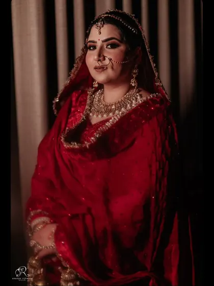A classic, dramatic portrait of the bride in her deep red wedding attire.