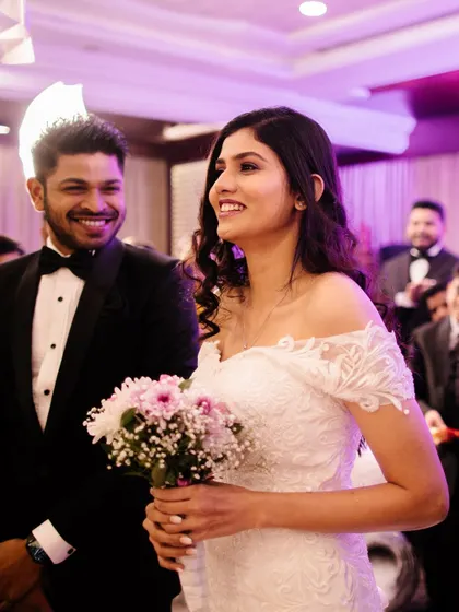 A beautiful moment between the bride and groom at their Christian wedding reception. Her makeup is a classic smokey eye, perfect for her elegant white dress.