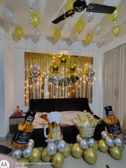 The birthday setup with "Aged to Perfection" and "Cheers" themed props.