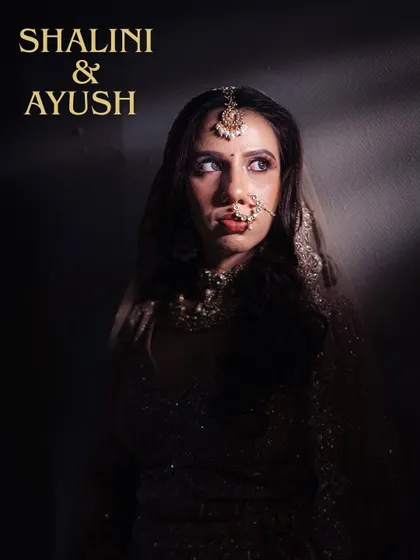 A dramatic, high-contrast portrait of the bride. The play of shadow and light highlights her features and traditional jewelry.