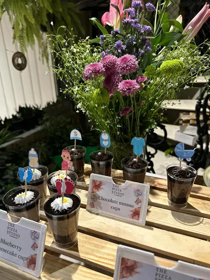 Themed desserts for a baby shower. We served blueberry cheesecake and chocolate mousse cups decorated with cute toppers like baby clothes and strollers to fit the celebration perfectly.