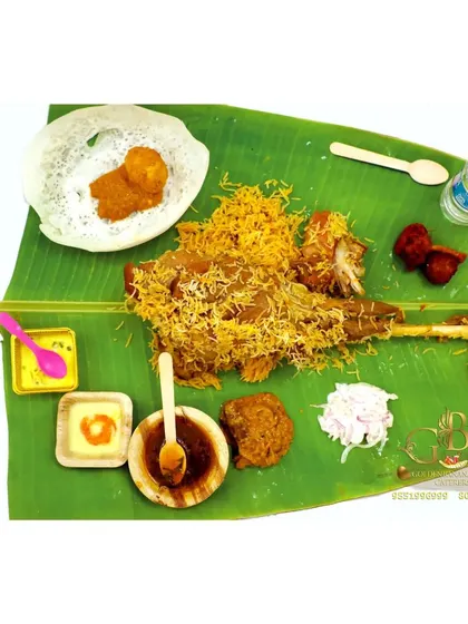A complete Raja Virundhu meal served on a banana leaf. It includes a leg of roasted mutton, biryani, appam, and various side dishes for a truly royal experience.