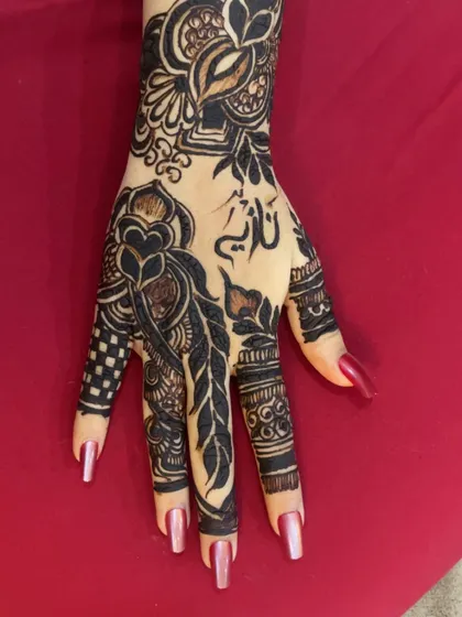 A modern Arabic design incorporating a feather motif and the name 'Nadia' in calligraphy.