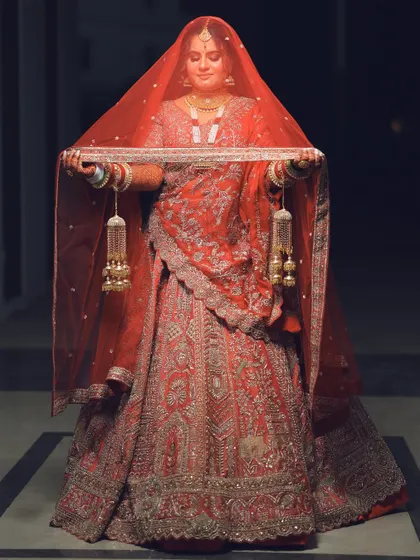 A traditional pose with the bride lifting her veil, creating a dramatic and elegant silhouette.