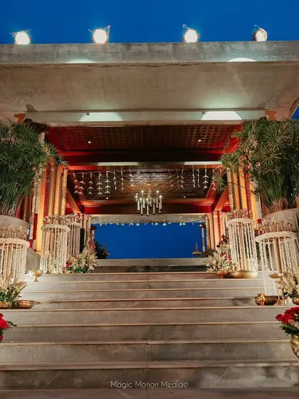 The grand staircase leading to the mandap, lined with traditional floral arrangements and brass lamps, creating a majestic entrance for the ceremony.