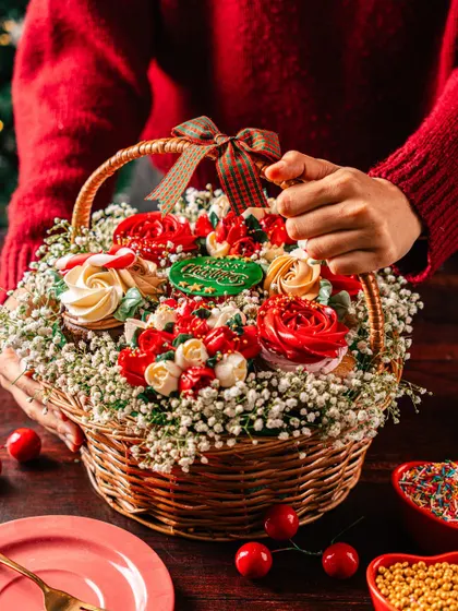Another angle of the Christmas cupcake bouquet, held to show its generous size and intricate presentation. It's a perfect Secret Santa gift or a centerpiece for a family gathering.
