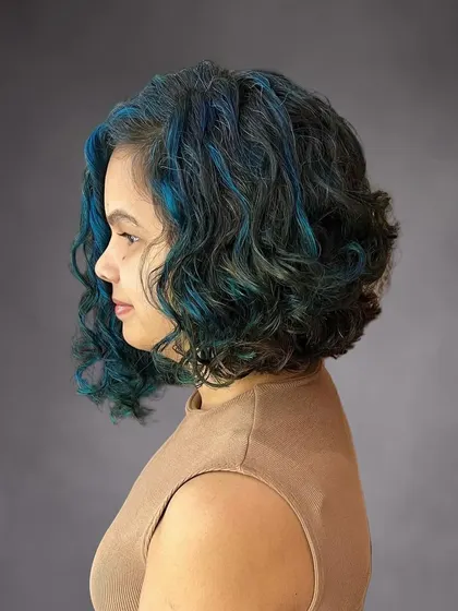 A side view of the curly bob with blue accents.