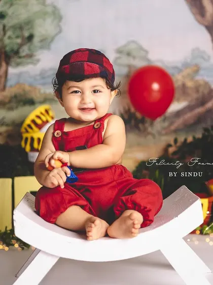 A classic Winnie the Pooh first birthday! This little one is all smiles, sitting in the Hundred Acre Wood with his favorite characters.