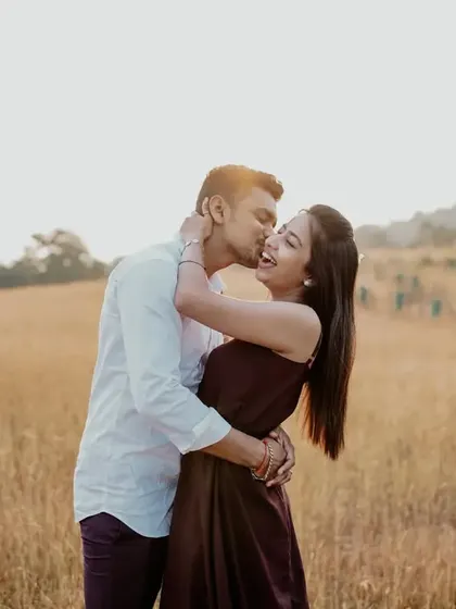 A sun-kissed, happy moment between the couple in an open field, full of warmth and genuine emotion.