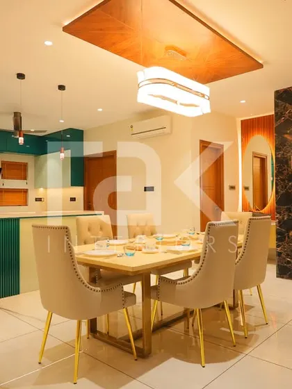 The open-plan dining and kitchen area in the Palakkad home, showcasing how different functional zones can be connected through a consistent design theme.