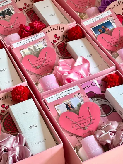 A delicate and thoughtful bridesmaid gift. This box includes a customized heart-shaped necklace, a satin scrunchie, a Zara pocket perfume, and a scented candle, all tied together with a personal photo card.