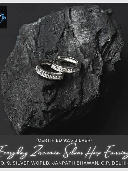 A slightly different angle of the zirconia hoops, emphasizing their sparkle against a dark, natural background.