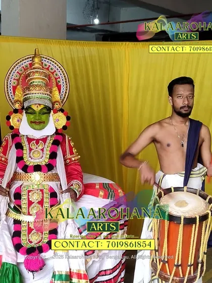 A behind the scenes look at our artists. A Kathakali performer stands in full costume next to a Chendemelam artist with his drum, showcasing two key elements of Kerala's performance arts.
