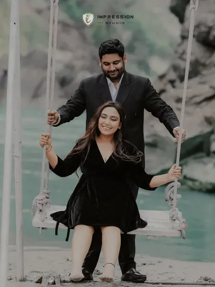 A playful moment on a swing by the water. This photo captures the carefree, joyful side of their relationship, showing that love is also about having fun and being kids at heart together.
