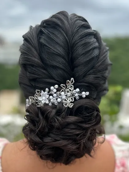 A very intricate and beautiful updo with a crystal and pearl hairpiece, perfect for a Christian bride or a reception.