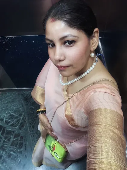 An elevator selfie showing the saree and a unique, artistic clutch, proving that great style is in the details.