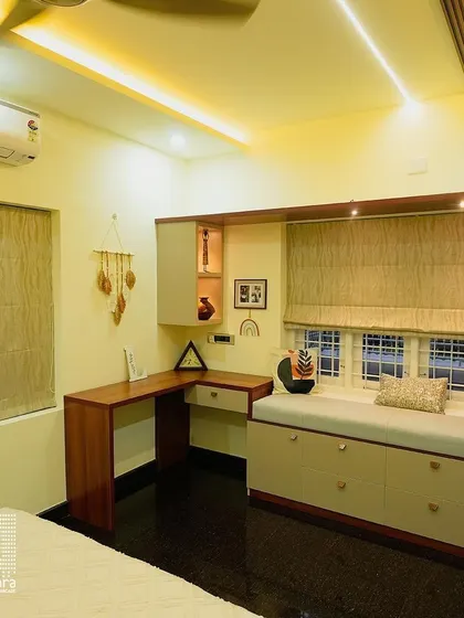 This multi-functional bedroom space includes a custom-built window seat with storage, paired with a corner study desk. The Roman blinds provide a clean and practical window treatment solution.