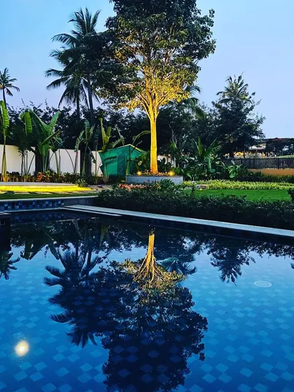 A tranquil evening view across the pool towards the garden, highlighting the seamless integration of water features and softscaping.
