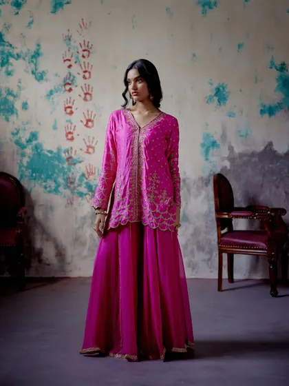 This striking fuchsia sharara set is perfect for summer soirées. The playful silhouette, vibrant colour, and delicate detailing make it a festive favourite for those who love to make a statement.