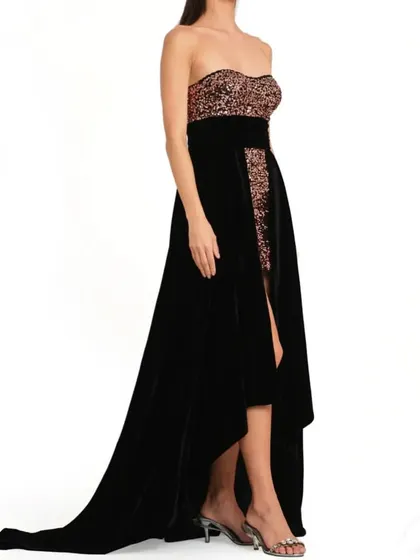 Our black velvet and rose gold sequin gown is perfect for a glamorous evening event. It features a high low skirt and a long train.