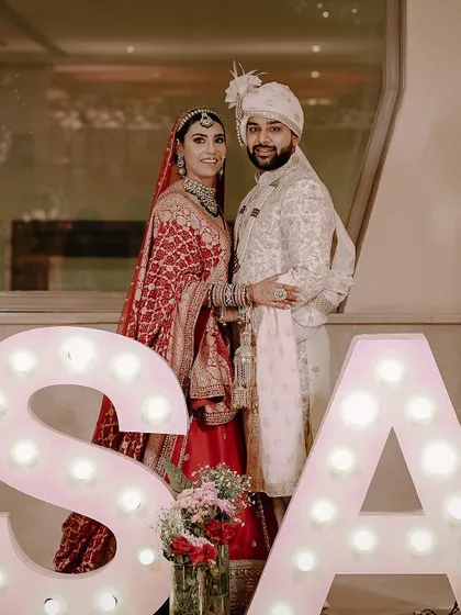 A fun portrait of the couple with marquee letters of their initials.