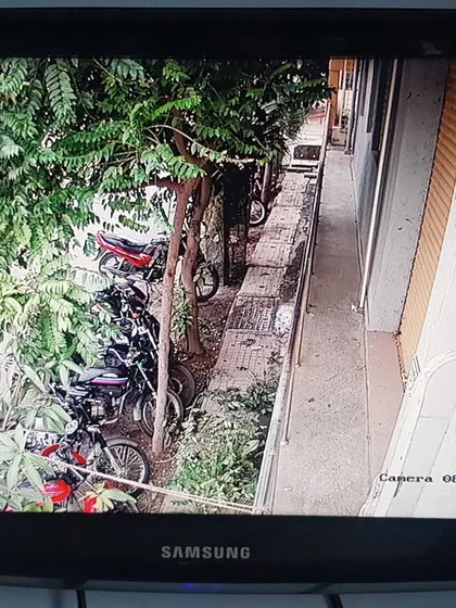 This camera is positioned to watch over a row of parked motorcycles along a narrow passage.