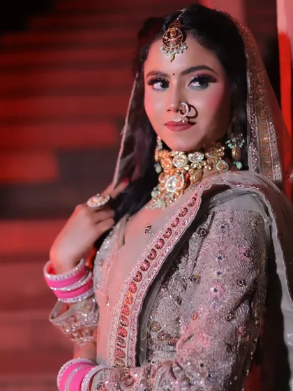 A portrait using dramatic red uplighting to create a modern, edgy look. The bride's pose against the wall is confident and stylish, showcasing a contemporary bridal aesthetic.