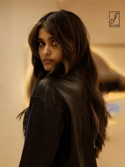 This shot captures a sense of movement and mystery, with a slightly blurred background and a sharp focus on the model's face.