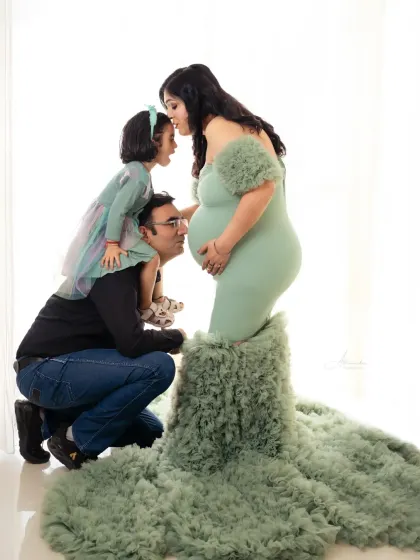 A creative and loving family maternity photo, with the whole family showering the baby bump with love.
