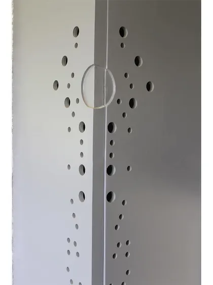 A detail of a perforated screen, used to create patterns of light and provide ventilation while maintaining privacy.
